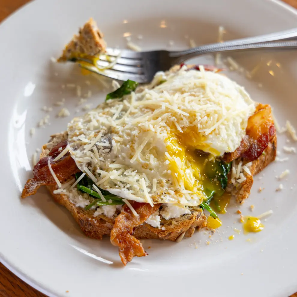 Florentine Toast is an over easy egg with bacon, sauteed spinach, and parmesan