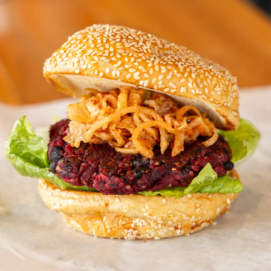 Our scratch-made menu features a beet and black bean burger, lettuce, kimchi, sesame bun for the best lunch in Annapolis